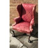 A WING BACK ARMCHAIR, with scrolled arms, with cabriole front legs and claw feet, 121cm x 69cm x