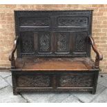 19TH CENTURY CARVED OAK BOX SETTLE, with four panelled back and hinged seat, 132cm x 137cm x 62cm