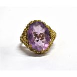 AN AMETHYST SINGLE STONE DRESS RING the amethyst approx. 16 x 12mm to an organic design head,