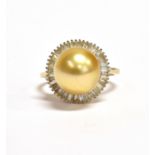 A MODERN SOUTH SEA GOLDEN PEARL AND DIAMOND CLUSTER RING The central round south sea cultured golden