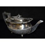 A SILVER CUSHION SHAPED TEAPOT With half fluted decoration and scroll and grooved border on four