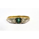 AN 18CT GOLD EMERALD AND DIAMOND THREE STONE RING The square cut emerald and two small illusion