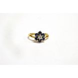 AN 18CT GOLD DIAMOND AND SAPPHIRE FLOWER HEAD CLUSTER RING the centre round brilliant cut diamond