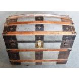 AN AMERICAN METAL BOUND DOME TOP TRAVELLING TRUNK the fitted interior with lift-out compartments and