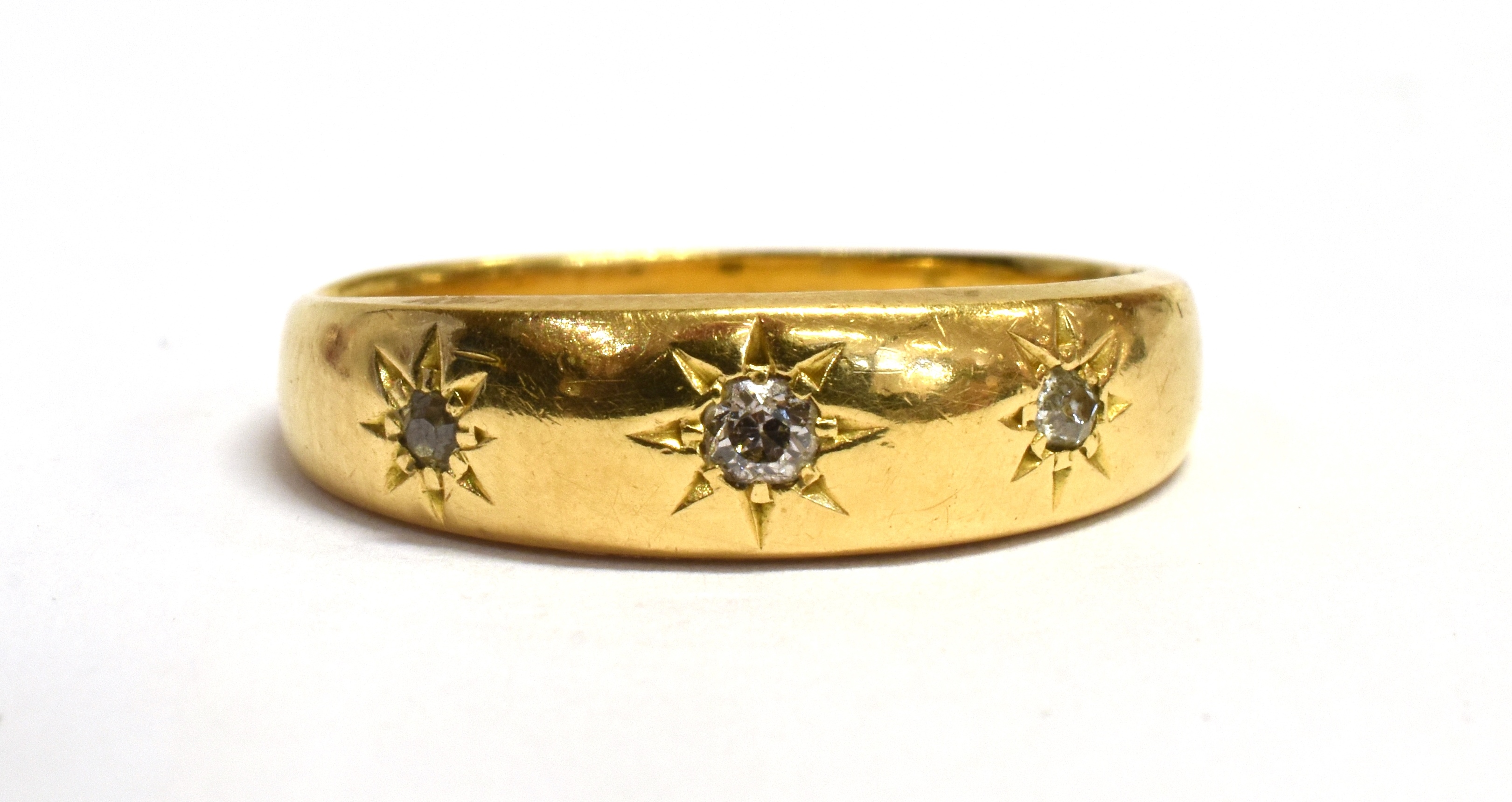 AN 18CT GOLD DIAMOND SET BAND RING Three small round cut diamonds gypsy star set to 18ct gold band