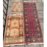 A RED GROUND RUNNER 80cm x 246cm; another with two medallions 85cm x 47cm, and another 63cm x