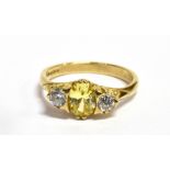 A CITRINE AND CUBIC ZIRCONIA THREE STONE DRESS RING The oval cut central Citrine approx. 7 mm x 5