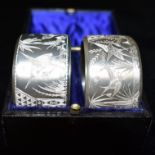A BOXED PAIR OF AESTHETIC PERIOD SILVER NAPKIN RINGS By George Unite with engraved scenes of birds