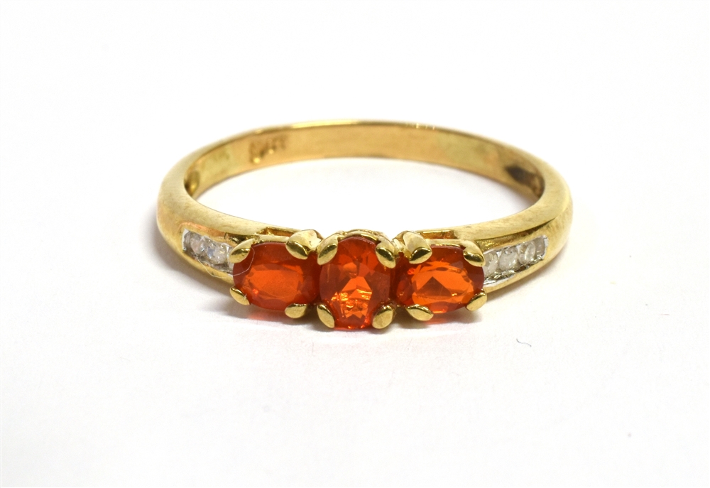 A FIRE OPAL THREE STONE 9CT GOLD RING The three oval cut fire opals approx. 4.5mm x 3mm, size N,