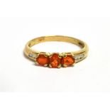 A FIRE OPAL THREE STONE 9CT GOLD RING The three oval cut fire opals approx. 4.5mm x 3mm, size N,