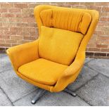 A G-PLAN STYLE SWIVEL WING ARMCHAIR on metal four prong base