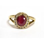 A 14CT GOLD RUBY AND WHITE CLUSTER RING (Note: The oval cut ruby 7mm x 5mm glass filled treated),