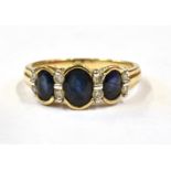 A SAPPHIRE THREE SET DIAMOND SET 9CT GOLD RING Three oval cut sapphires, centre sapphire 6mm x