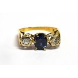 A SAPPHIRE AND DIAMOND THREE STONE 18CT GOLD RING The central oval cut sapphire 7mm x 5mm, two