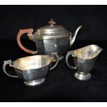 A SILVER THREE PIECE TEA SET The plain form tea set with canted corners on pedestal base composition