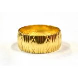 A HALLMARKED 18CT GOLD PATTERNED WEDDING BAND The grooved and star cut patterned ring 8mm wide, size