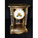 A FRENCH BRASS CASED MANTLE CLOCK BY SAMUEL MARTI & CO with bevelled glass throughout and bowed