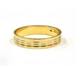 AN 18CT GOLD PATTERNED WEDDING BAND The flat section ring 4mm wide, with a three row pattern,