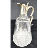 A VICTORIAN SILVER TOPPED CUT GLASS CLARET JUG The silver top with hinged lid and scroll handle