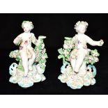 A PAIR OF ENGLISH 18TH CENTURY PORCELAIN FIGURES modelled as cherubs seated on floral decorated tree