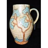 A LARGE 1930S CROWN DEVON JUG decorated with trees on a mottled yellow ground, 33cm high Condition