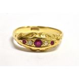 A C1900 RUBY AND DIAMOND SET BOAT HEAD RING the central ruby approx. 3mm diameter, the shank stamped