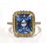 A SYNTHETIC BLUE SPINEL AND WHITE STONE 9 CT GOLD CLUSTER RING The synthetic blue spinel 10mm x 8mm,