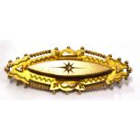 A VICTORIAN 9CT GOLD ETRUSCAN STYLE BROOCH The eliptical shaped brooch with small diamond to centre,