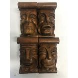 FOUR WOODEN CORBELS, carved in the form of male heads each with a different expression, 21cm high