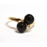 A 9CT GOLD BLACK CORAL TWO BEAD RING the cross-over design comprising two black coral beads with