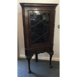 AN OAK CORNER CABINET ON STAND, with glazed door above a central small drawer, 162cm x 82cm x 46cm