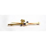 AN EDWARDIAN SMALL SAPPHIRE AND SEED PEARL SET YELLOW GOLD BAR BROOCH The shamrock design to plain