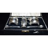 A BOXED SILVER THREE PIECE CRUET SET Of plain circular form with bullet shaped pepperette,