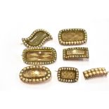 SEVEN 19TH CENTURY SEED PEARL SET MOURNING BROOCHES Of assorted shapes, six of them with plaited