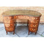 A KIDNEY SHAPED DESK, the top having a green leather insert, above a central drawer flanked by