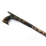 A PHILIPPINE CARVED WOOD WALKING STICK with mother of pearl inlay, 99.5cm long.