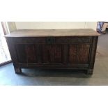 AN OAK COFFER, with carved decoraton to the front and with three plain panels, 68cm x 140cm x 47cm
