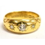 A VICTORIAN 22CT GOLD BAND RING gypsy set with three round old cut diamonds, the larger centre