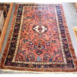 A RED GROUND RUG the border with stylised animals, 130cm x 220cm Condition Report : generally good