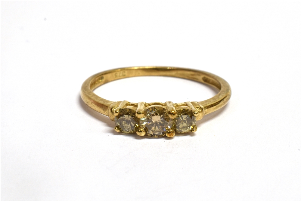 A CHAMPAGNE DIAMOND THREE STONE 9CT GOLD RING The three champagne coloured diamonds weighing a total