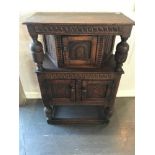 AN OAK COURT CUPBOARD, of small proportion, having a carved central door, above two carved doors ,