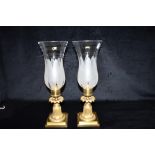 A PAIR OF 19TH CENTURY GILT METAL CANDLESTICKS with hurricane glass shades, 38cm high Condition