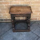 AN OAK JOINT STOOL, with rectangular top above a carved frieze and raised on four turned legs united