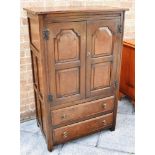 AN OAK AND ELM TALL BOY, the twin doors opening to reveal a fitted shelf above two long drawers,
