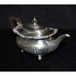 A LATE VICTORIAN SILVER TEAPOT With ebonised handle and lid top knob, on four ball feet, fluting