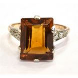 A GOLD DRESS RING set with a step cut dark citrine or citrine coloured stone with diamond accented