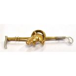 A 9CT GOLD RIDING CROP BROOCH with a central horse head in horse shoe, white gold detail to ends,
