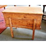 A FRENCH PINE DOUGH BIN with a hinged lid, raised on square, slightly splayed supports,