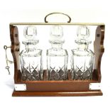 AN EPNS MOUNTED THREE BOTTLE TANTALUS 39cm wide 35cm high Condition Report : decanters and