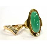 A YELLOW METAL STATEMENT RING set with an oval opaque green cabochon measuring 2.7cm long